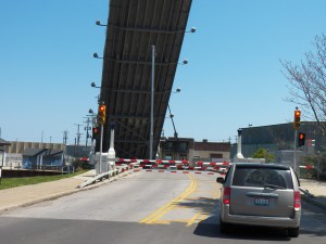 A sailboat passes under the lift bridge